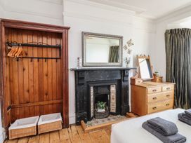 A bedroom with a wardrobe and a fireplace at Wavecrest in Pwllheli