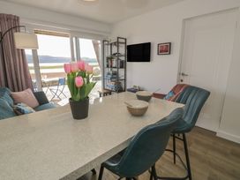 A living room with a sofa, table and chairs at Lan y Mor in Porthmadog