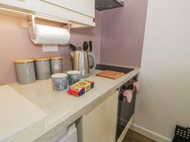 A kitchen with utensils and mugs on a countertop at Lan y Mor in Porthmadog