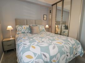 A bedroom with a bed and wardrobe at Lan y Mor, Porthmadog