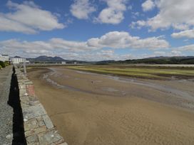 A view of the beach with sand and water at Lan y Mor in Porthmadog