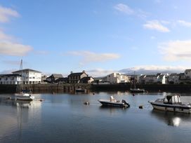 A view of boats in a harbor with buildings in the background at Lan y Mor Porthmadog