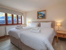 A bedroom with two single beds and a painting at The Old Byres in Washford near Watchet