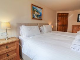 A bedroom with two beds and a painting on the wall at The Old Byres in Washford near Watchet