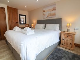 A bedroom with a large bed and towels at The Old Byres in Washford near Watchet