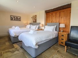 A bedroom with two beds and nightstands at The Old Byres in Washford near Watchet