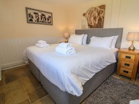 A bedroom with a bed and two lamps at The Old Byres in Washford near Watchet