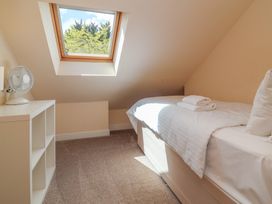 A bedroom with a bed and a fan at The Old Byres Washford near Watchet