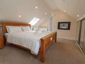 A bedroom with a bed and a mirror at The Old Byres in Washford near Watchet