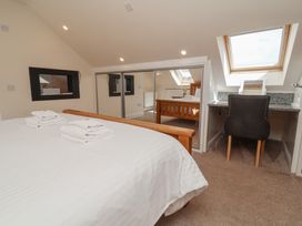 A bedroom with a bed, desk, and chair at The Old Byres in Washford near Watchet