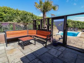 An outdoor area with seating and a pool at The Old Byres in Washford near Watchet