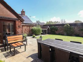 A garden with a table and chairs at The Old Byres in Washford near Watchet