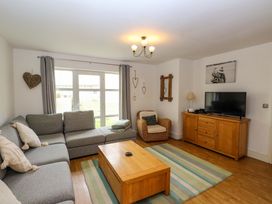 A living room with a sofa and television at The Bungalow in Morfa Nefyn near Pwllheli