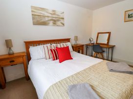 A bedroom with a bed and desk at The Bungalow in Morfa Nefyn near Pwllheli