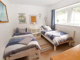 A bedroom with two beds and a lamp at The Bungalow in Morfa Nefyn near Pwllheli