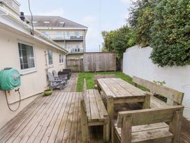 A garden with a wooden deck and furniture at The Bungalow in Morfa Nefyn near Pwllheli