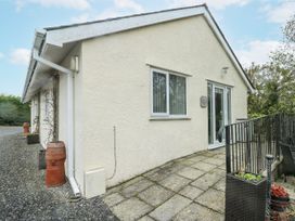 An exterior view of a house with a patio and planter at Rhosydd Cottage in Benllech