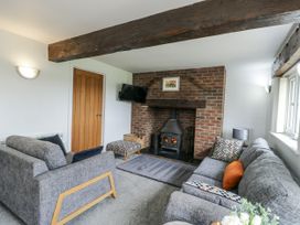 A living room with a fireplace and sofa at Rhosydd Cottage in Benllech