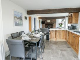A dining room with a table set for dinner at Rhosydd Cottage in Benllech