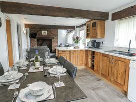A kitchen with a dining table and chairs at Rhosydd Cottage Benllech