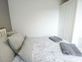 A bedroom with towel and pillows at Rhosydd Cottage Benllech