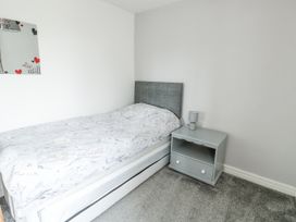 A bedroom with a bed and nightstand at Rhosydd Cottage Benllech