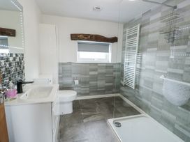 A bathroom with a wash basin and a shower at Rhosydd Cottage Benllech