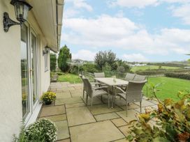 An outdoor area with a table and chairs at Rhosydd Cottage in Benllech