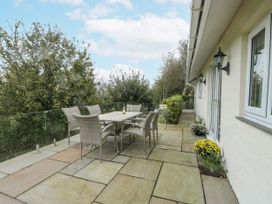 An outdoor patio with a table and chairs at Rhosydd Cottage in Benllech