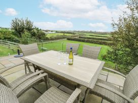 An outdoor dining area with a table and chairs at Rhosydd Cottage Benllech