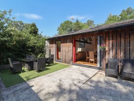 An outdoor area with seating and an open door at Zeal Cottage in Crediton