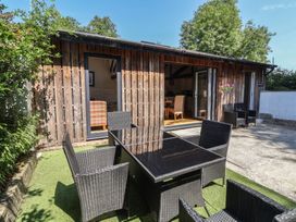 A garden with an outdoor table and chairs at Zeal Cottage in Crediton