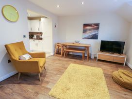 A living room with an armchair and a table at Y Enciliad Rhosneigr
