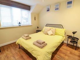 A bedroom with a bed and window at Y Enciliad Rhosneigr
