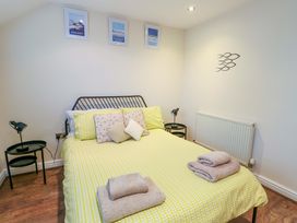 A bedroom with a bed and bedside lamps at Y Enciliad Rhosneigr