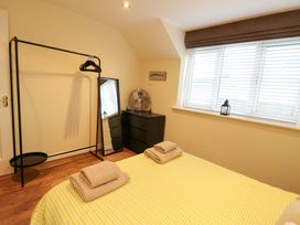 A bedroom with a bed and towels on it at Y Enciliad in Rhosneigr