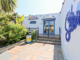 The entrance to Tropicana Fun Pools with stairs surrounded by plants and a trash bin at La Capsule in Dawlish Warren