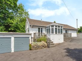 An exterior view of a house with a conservatory and garage at Mylnebeck Lodge Bowness-on-Windermere