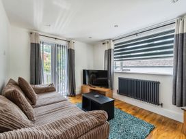 A living room with a sofa and television at Mylnebeck Lodge in Bowness-on-Windermere