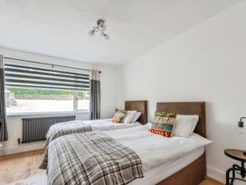 A bedroom with two beds and a window at Mylnebeck Lodge in Bowness-on-Windermere