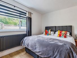 A bedroom with a bed and window at Mylnebeck Lodge in Bowness-on-Windermere