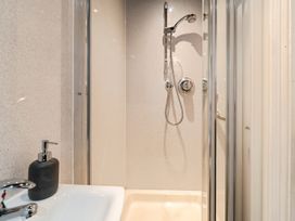 A shower area with a sink and soap dispenser at Mylnebeck Lodge in Bowness-on-Windermere
