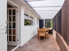 A conservatory with a table and chairs at Mylnebeck Lodge in Bowness-on-Windermere