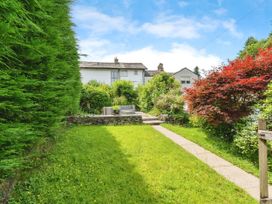 A garden with a pathway and seating area at Mylnebeck Lodge in Bowness-on-Windermere