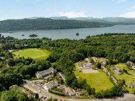 An aerial view of a lake surrounded by trees and buildings at Mylnebeck Lodge Bowness-on-Windermere