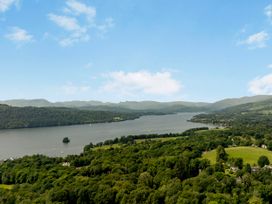 A view of a lake surrounded by greenery and mountains at Mylnebeck Lodge in Bowness-on-Windermere