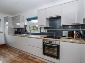 A kitchen with cabinets, sink, and appliances at Blaenywawr near Lampeter