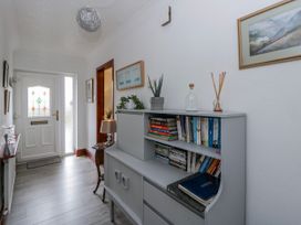 A hallway with a bookshelf and front door at Blaenywawr near Lampeter