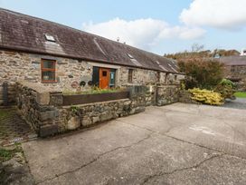 A stone building with windows and a garden area at Beudy Mawr Y Felinheli