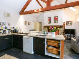 A kitchen with appliances and a living area at Beudy Mawr in Y Felinheli